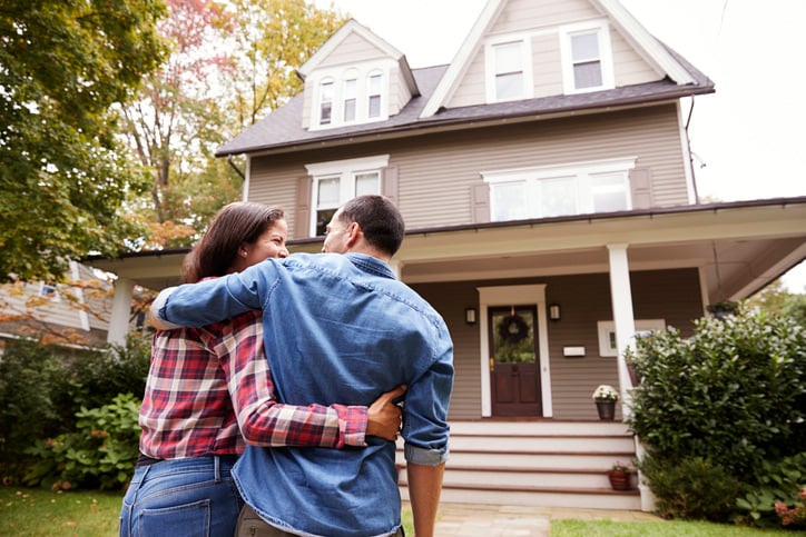Buying couple in front of home